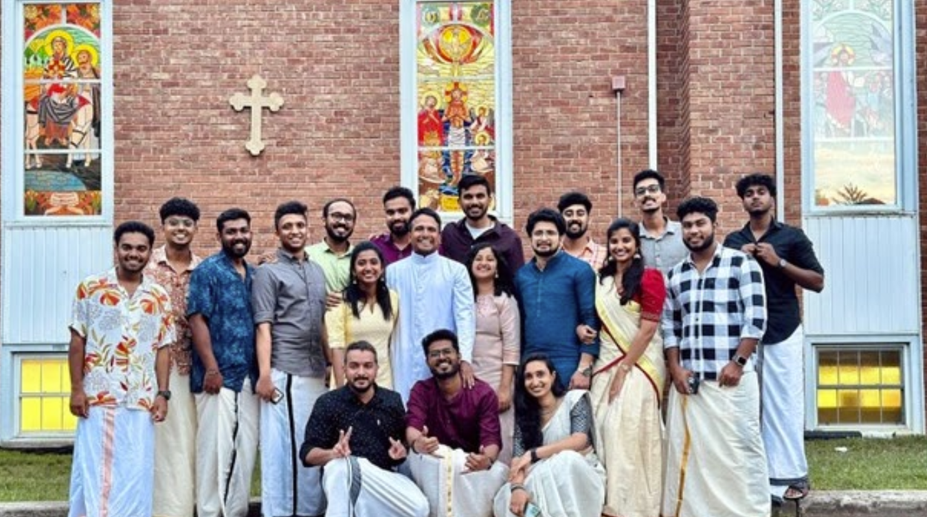 Vibrant group of MCYM youth members gathered outside the church in traditional and modern attire, representing the active Malankara Catholic Youth Movement